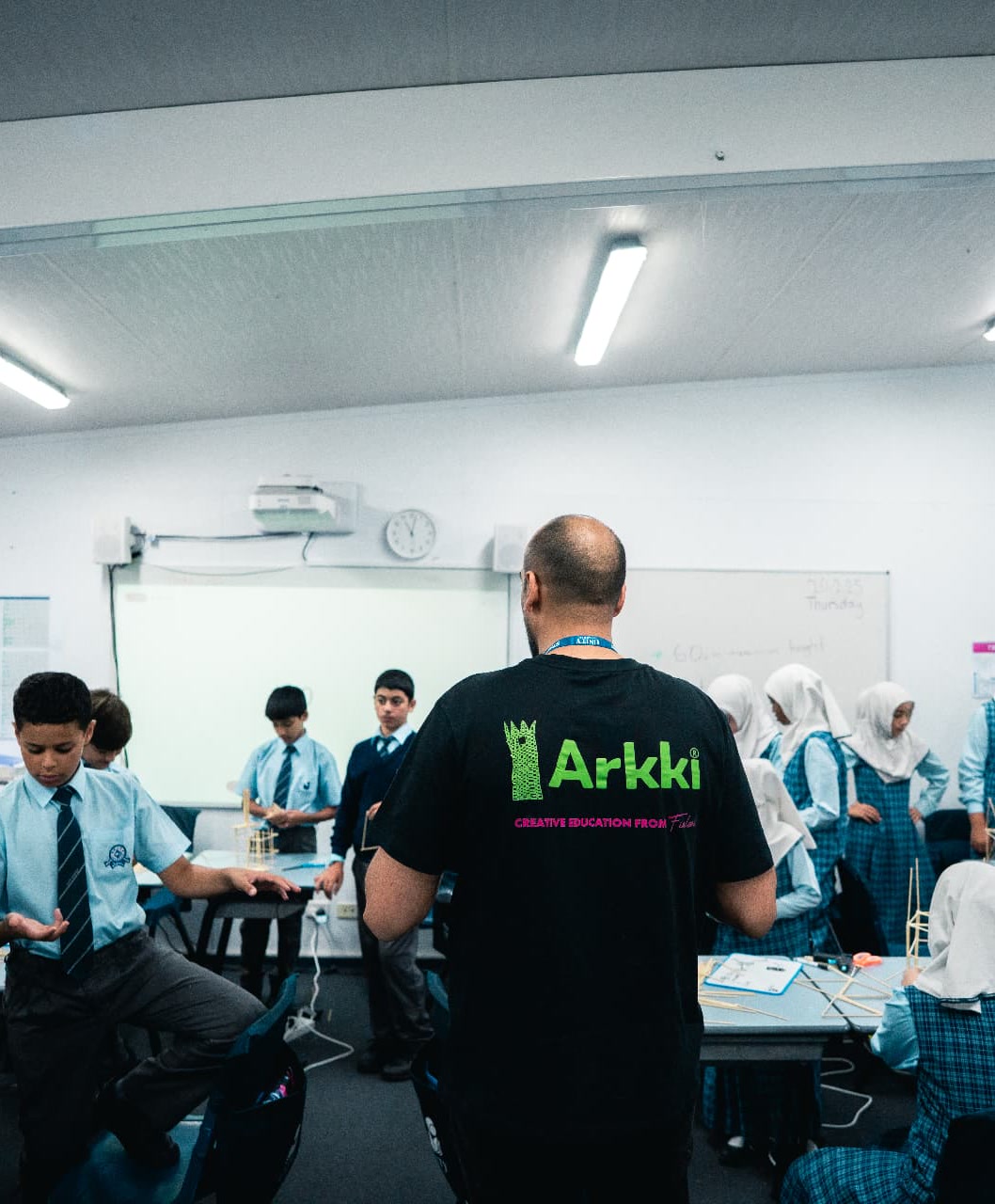 An Arkki facilitator working with students on hands-on architecture and design projects in a classroom.